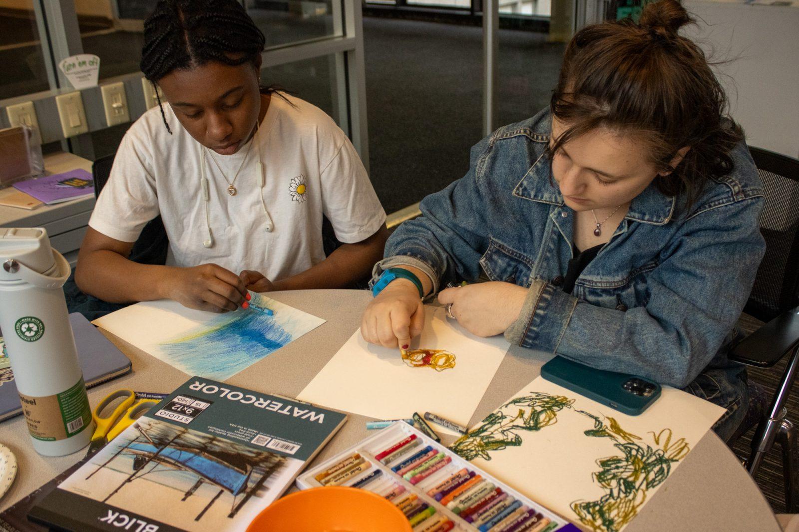 Martha Sengor (left) and Jaedin Guldenstern (right) create art during a “Curating the Body” session on Wednesday. The art series will be on display during a final showcase on April 29 at the LGBTQIA+ Student Resource Center. ISABELLA OLAND/DFP PHOTOGRAPHER