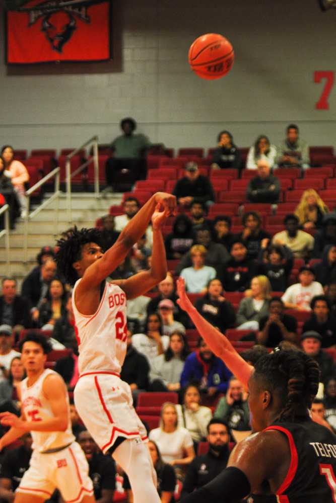 Boston University team captain Miles Brewster (24) shoots in a game against Northeastern University in November 2022.