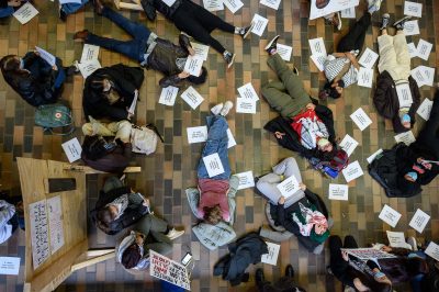 Protesters lay on the floor at a die-in protest organized by Boston University Students for Justice in Palestine in the George Sherman Union on Dec. 1. Earlier that day, BU Students for Israel set up a display in Marsh Plaza of empty chairs representing people kidnapped by Hamas.