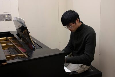 student plays the piano in the college of fine arts