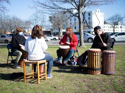 circle of people playing drums