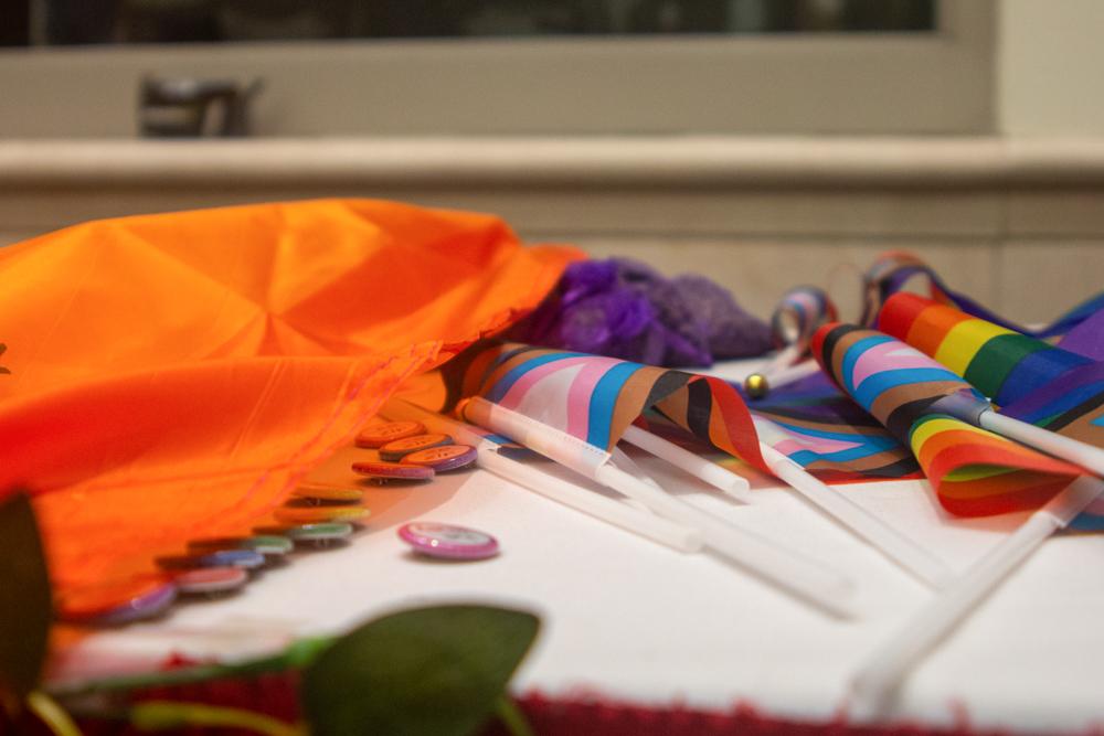 Pride flags, pins and bags of lavender adorn a table at the Boston University Lavender Ceremony on May 20