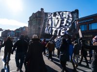 Protestor carrying a Black Lives Matter Flag at a Mass Action Against Police Brutality Protest in Boston