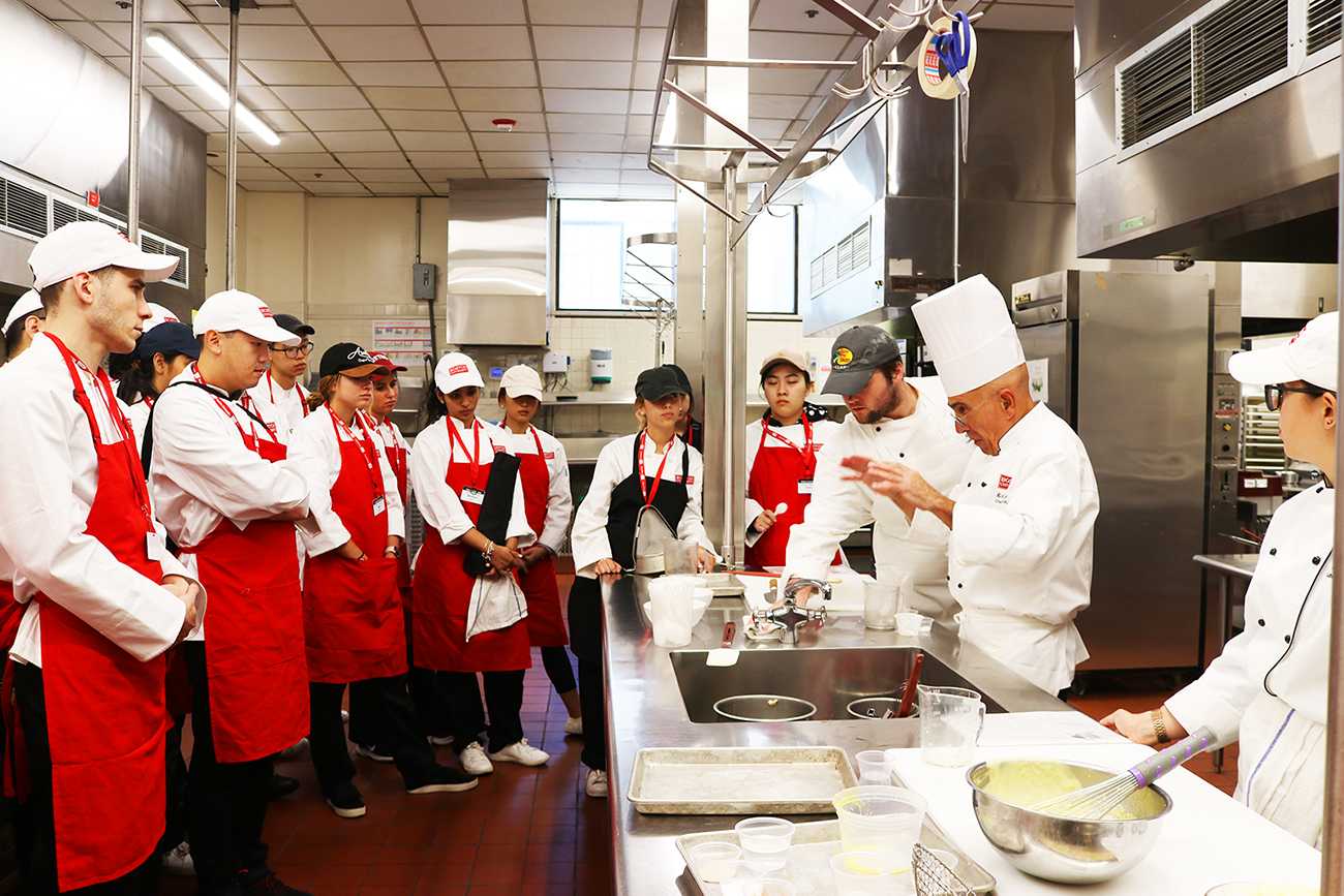  Students gather around Chef Nick Schiarizzi, professor in the School of Hospitality who teaches the course, “Principles of Food Production Management.” LIBBY MCCLELLAND/ DAILY FREE PRESS STAFF
