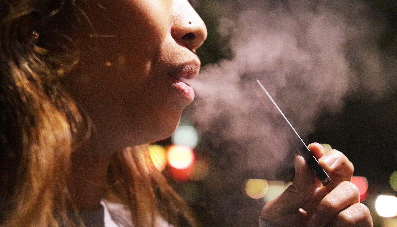 A Boston University student uses a Juul. Nationwide concerns about the harmful health effects of e-cigarettes have raised awareness on the range of vaping products prevalent on college campuses. ILLUSTRATION BY SOFIA KOYAMA/ DAILY FREE PRESS STAFF