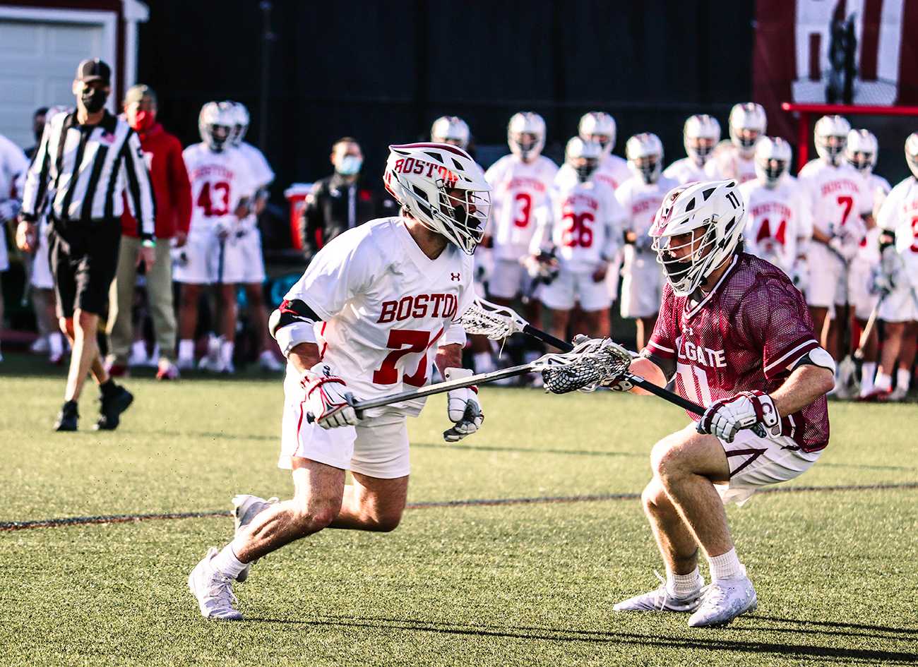 matt baugher runs around a colgate university defender