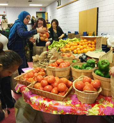 Students and faculty of Kennedy Longfellow Elementary School in Cambridge participate in the K-Lo market, a program started by the Food For Free organization which provides local families free nutritious foods. PHOTO COURTESY SASHA PURPURA  