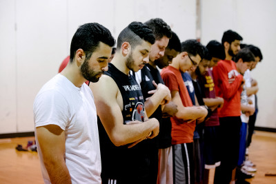 Participants at the Hoop for Syria fundraiser tournament pray before starting the basketball matches Saturday at the SAC Gym. PHOTO BY BRIAN SONG/DAILY FREE PRESS STAFF