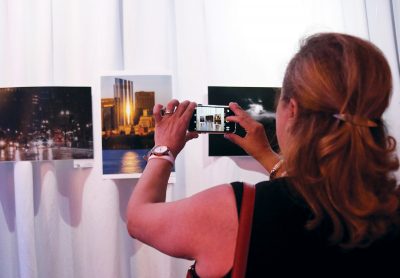 A woman photographs a display at the IGersBoston photography exhibit showcasing Instagram photos of Boston. PHOTO BY KANKANIT WIRIYASAJJA/ DAILY FREE PRESS STAFF