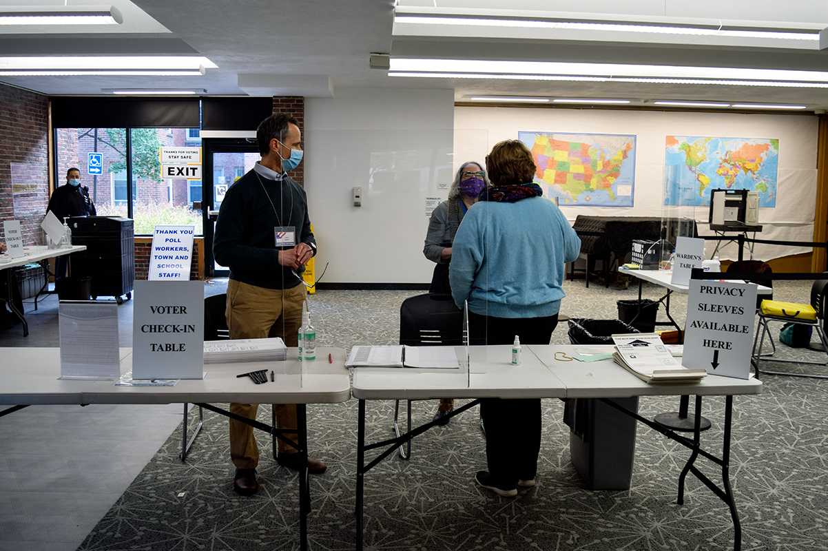 Poll workers socializing at Coolidge Corner’s Precinct 2 polling location. Voters’ rights advocacy organizations helped recruit poll workers for the Nov. 3 election. SOPHIA FLISSLER | DAILY FREE PRESS STAFF