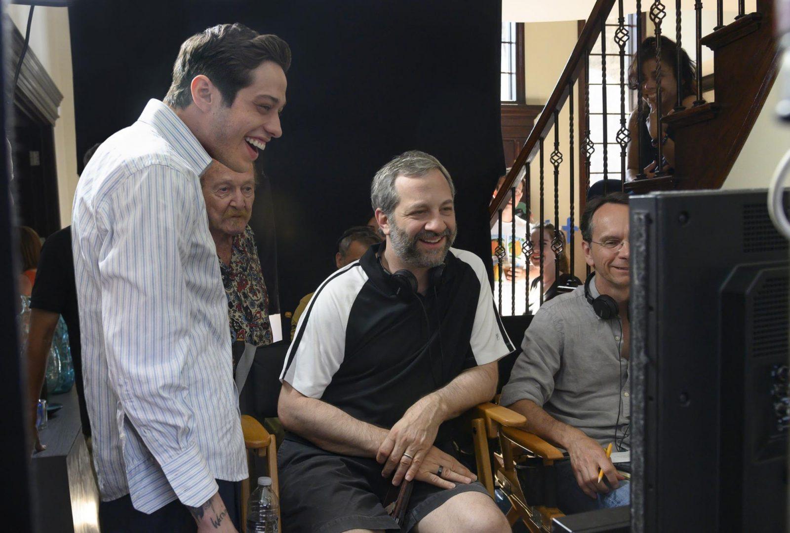 Pete Davidson and director Judd Apatow with crew members on the set of "The King of Staten Island." Apatow said in a roundtable interview that Davidson's touching past inspired an authentic film. COURTESY OF KEVIN MAZUR