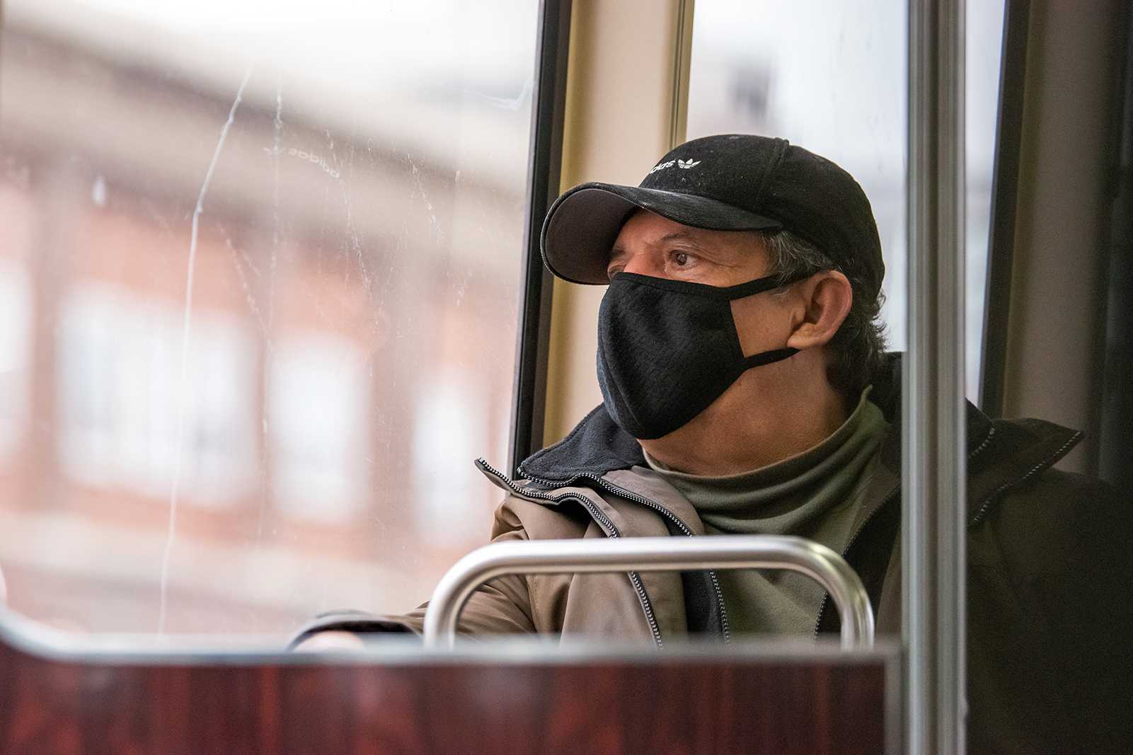 A person wearing a mask rides the B-line train to Boston College. Through its new Ride Safer program, the Massachusetts Bay Transportation Authority has begun distributing free face masks to passengers in an effort to limit the spread of COVID-19. LAURYN ALLEN/ DFP FILE