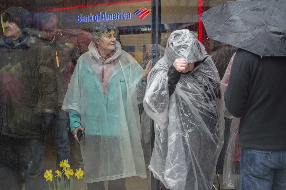 People take shelter from the rain during the 2019 Boston Marathon. The first nor’easter of the season is rolling through the state, bringing rains to Boston until Saturday. MADDIE MALHOTRA/ DFP FILE