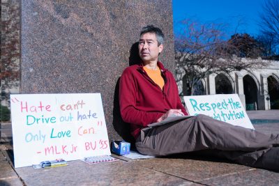 Nathan Phillips, a professor in Boston University's Department of Earth and Environment, sits in Marsh Plaza in support of racial, gender and religious equality Monday afternoon. PHOTO BY BRIAN SONG/ DAILY FREE PRESS STAFF