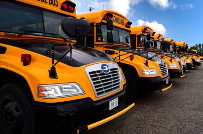 Row of electric school buses in a lot