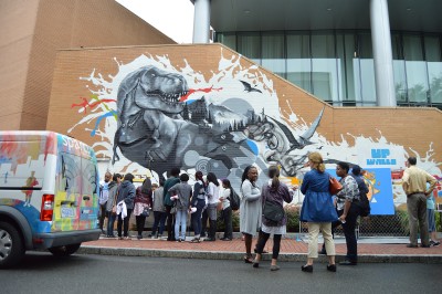 Attendees of a celebration for the New England Foundation of the Arts view the newly unveiled mural by Cedric Douglass in celebration of the new UP Walls program. PHOTO BY ERIN BILLINGS/ DAILY FREE PRESS STAFF