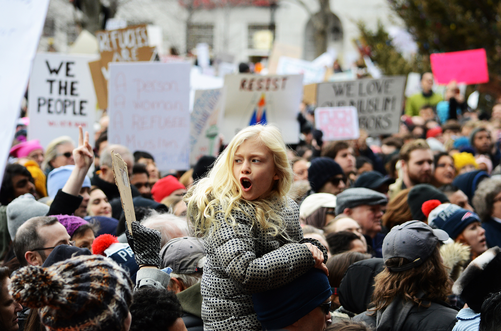A young girl chants on her father's shoulders at the Protest Against Muslim Ban and Anti-Immigration Orders Sunday afternoon in Copley Square. PHOTO BY VIGUNTHAAN THARMARAJAH/ DAILY FREE PRESS STAFF