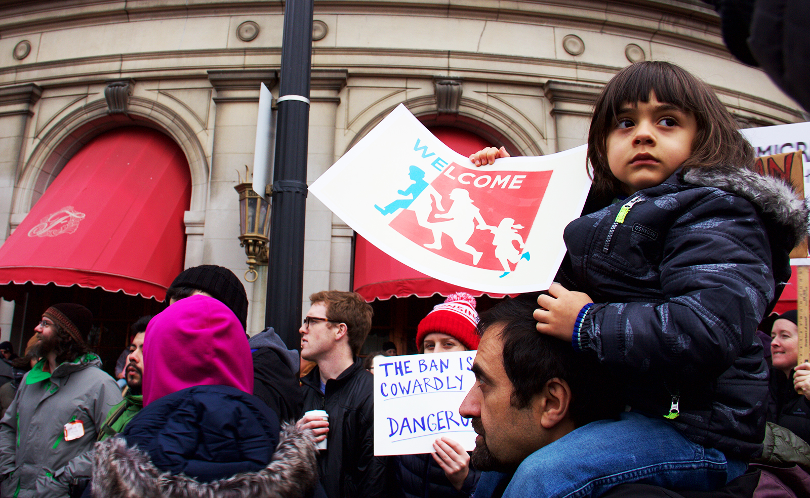 Nima, a child of Iranian parents, sits on her father’s shoulder as she participates in the protest against the recent Muslim ban in Copley Square Sunday afternoon. PHOTO BY OLIVIA FALCIGNO/ DAILY FREE PRESS STAFF