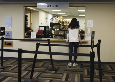 A student waits in line at the print center inside Mugar Memorial Library, where the student employee position will be eliminated at the end of the semester. PHOTO BY NATALIE CARROLL/ DAILY FREE PRESS STAFF 