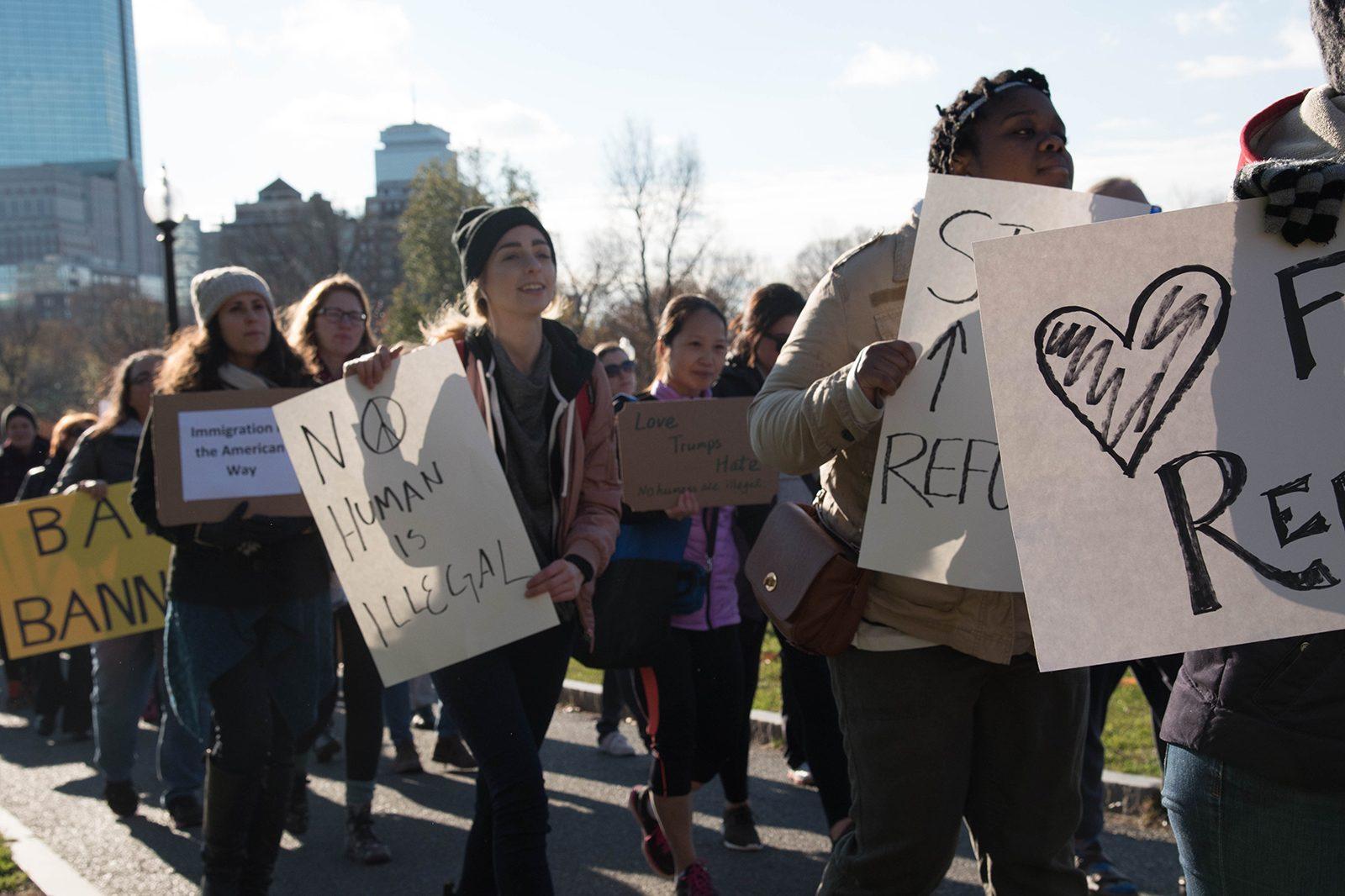 Protesters march with signs at the "No Human is Illegal: Standing up for Refugees and Immigrants" rally in the Boston Common Sunday afternoon. PHOTO BY LAUREN PETERSON/ DAILY FREE PRESS STAFF