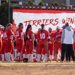 boston university softball team in front of a terriers win sign