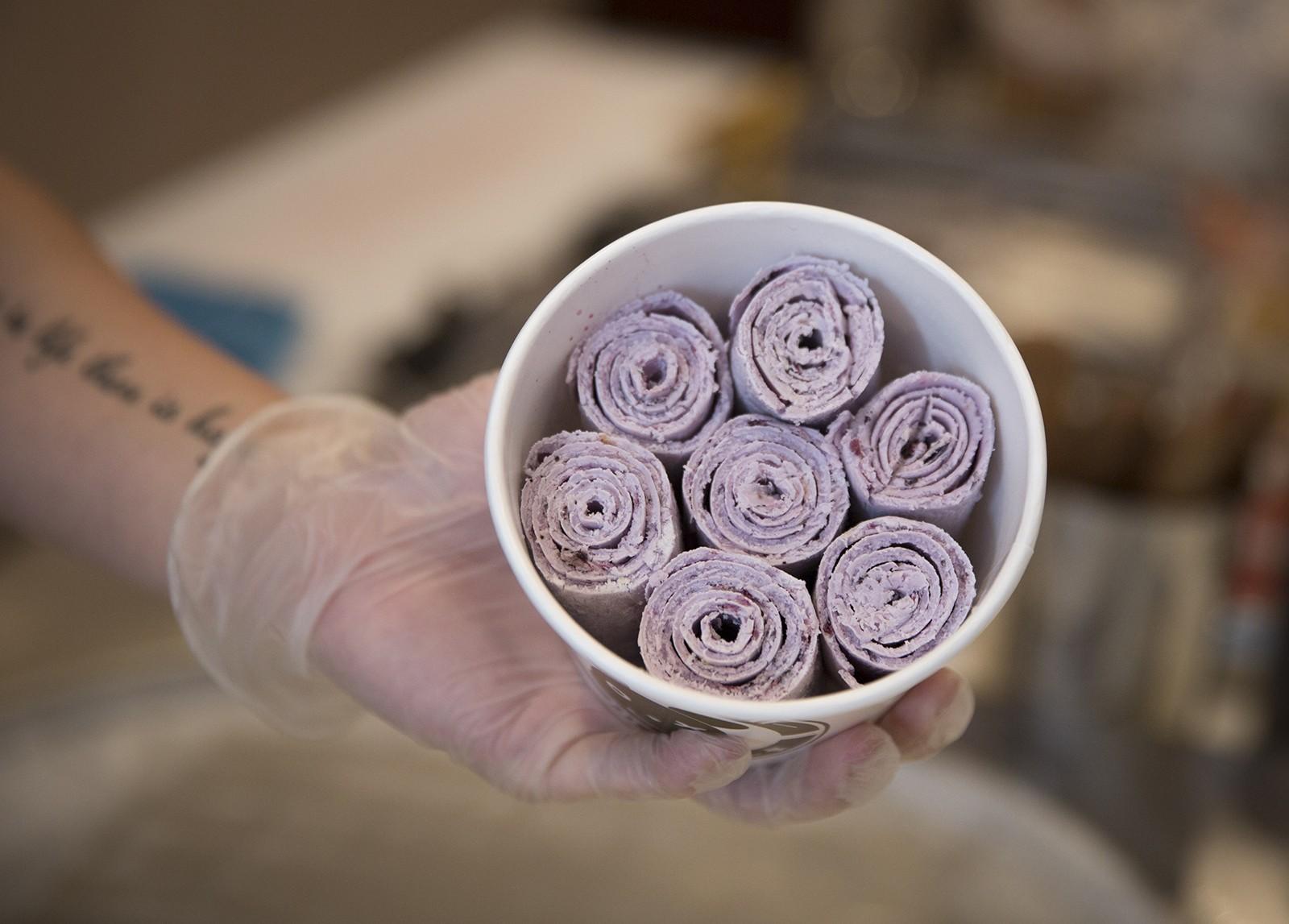 An employee at Hi B3ar in Allston holds a bowl of rolled ice cream. PHOTO BY SARAH SILBIGER/ DAILY FREE PRESS STAFF