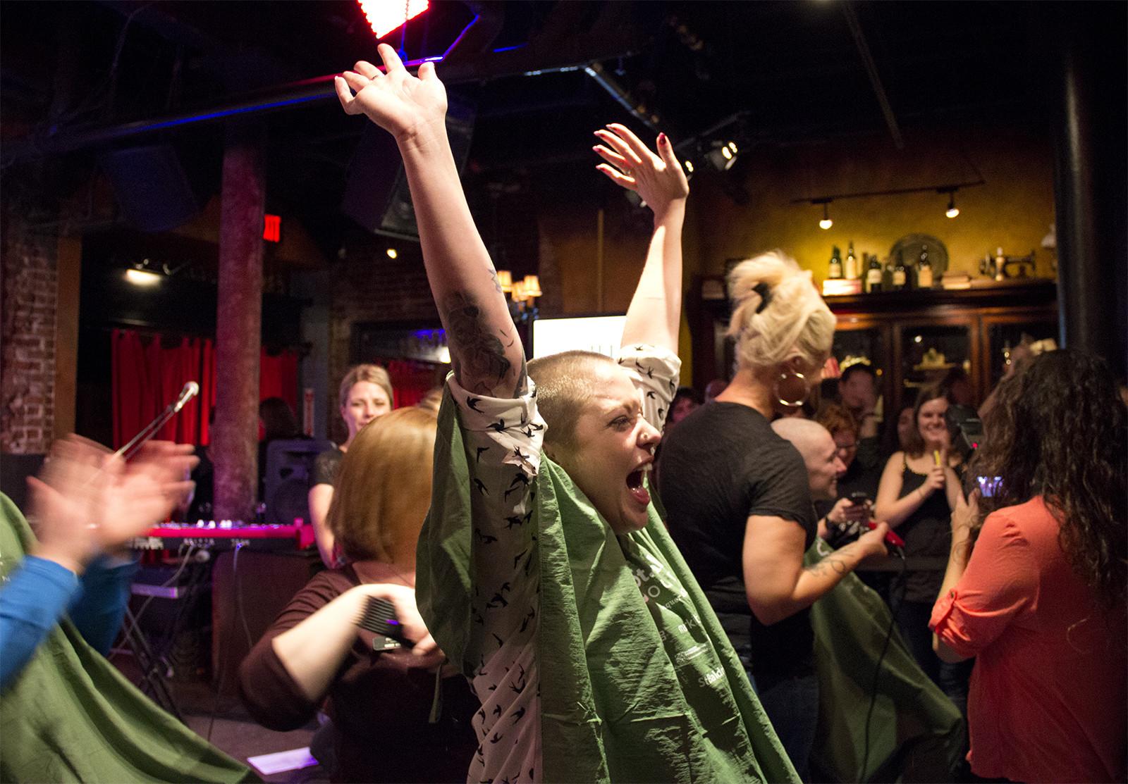 One of the first participants celebrates after shaving her head during the fourth annual St. Baldrick’s Charity Cup to raise money for pediatric cancer on Monday at Lansdowne Pub. PHOTO BY MARY SCHLICHTE/DAILY FREE PRESS STAFF
