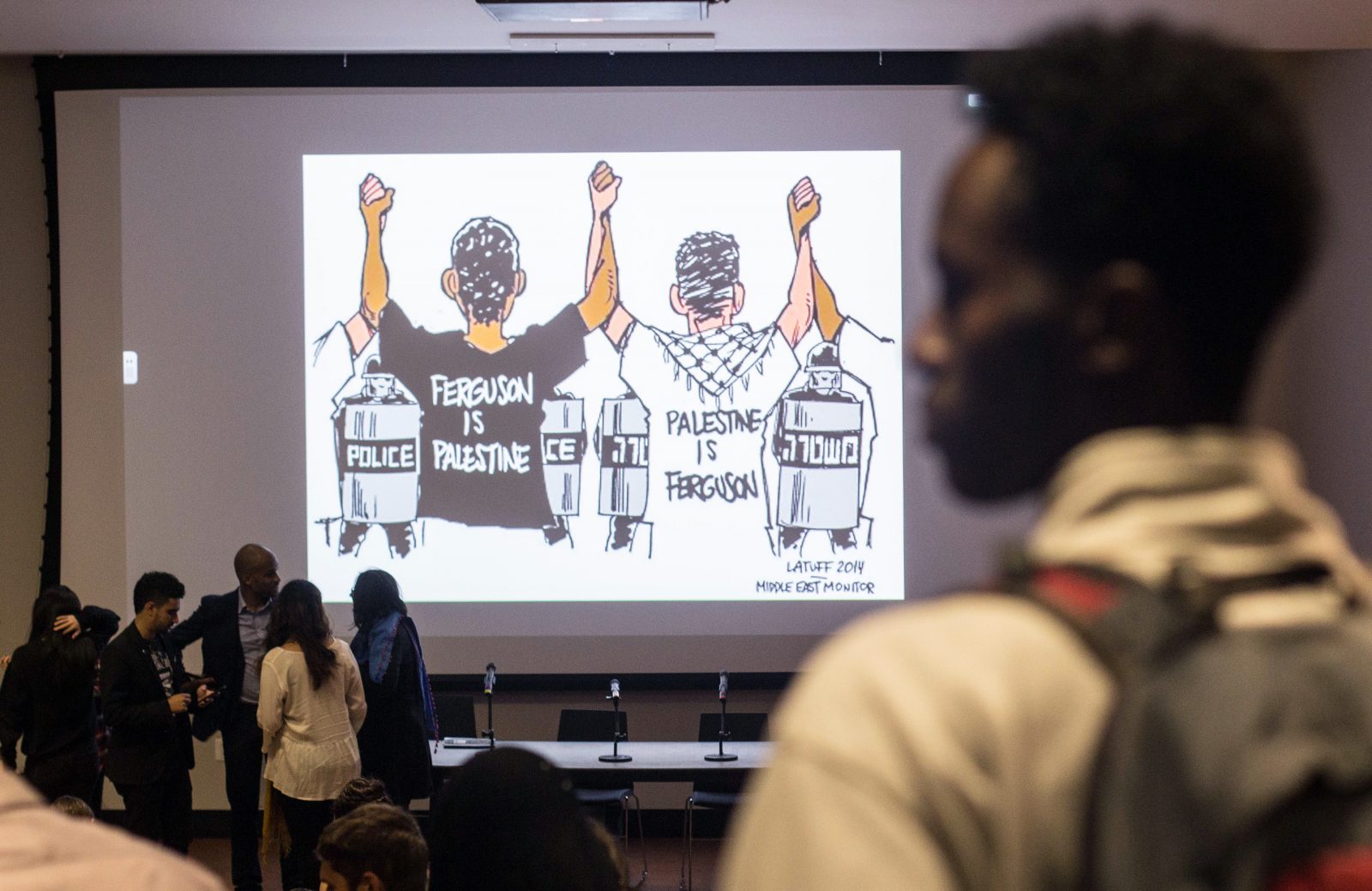A political cartoon projected on the screen after a Students for Justice in Palestine panel shows the perceived relationship between the Black Lives Matter and the Palestinian Liberation movements. PHOTO BY ISABELLE NGUYEN-PHUOC/ DAILY FREE PRESS CONTRIBUTOR 
