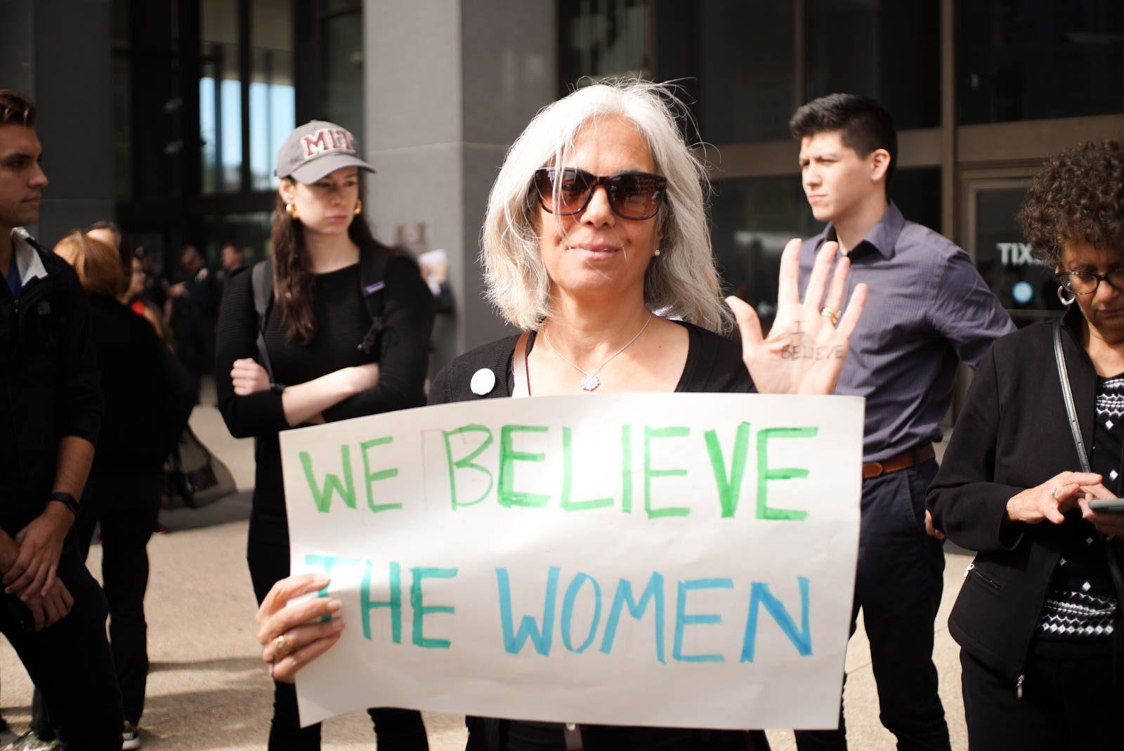 Alison Arnstein holds a sign at a speakout Thursday in support of Christine Blasey Ford. Ford testified in front of the United States Congress about her sexual assault allegations against Supreme Court nominee Brett Kavanaugh. SOPHIE PARK/ DAILY FREE PRESS STAFF