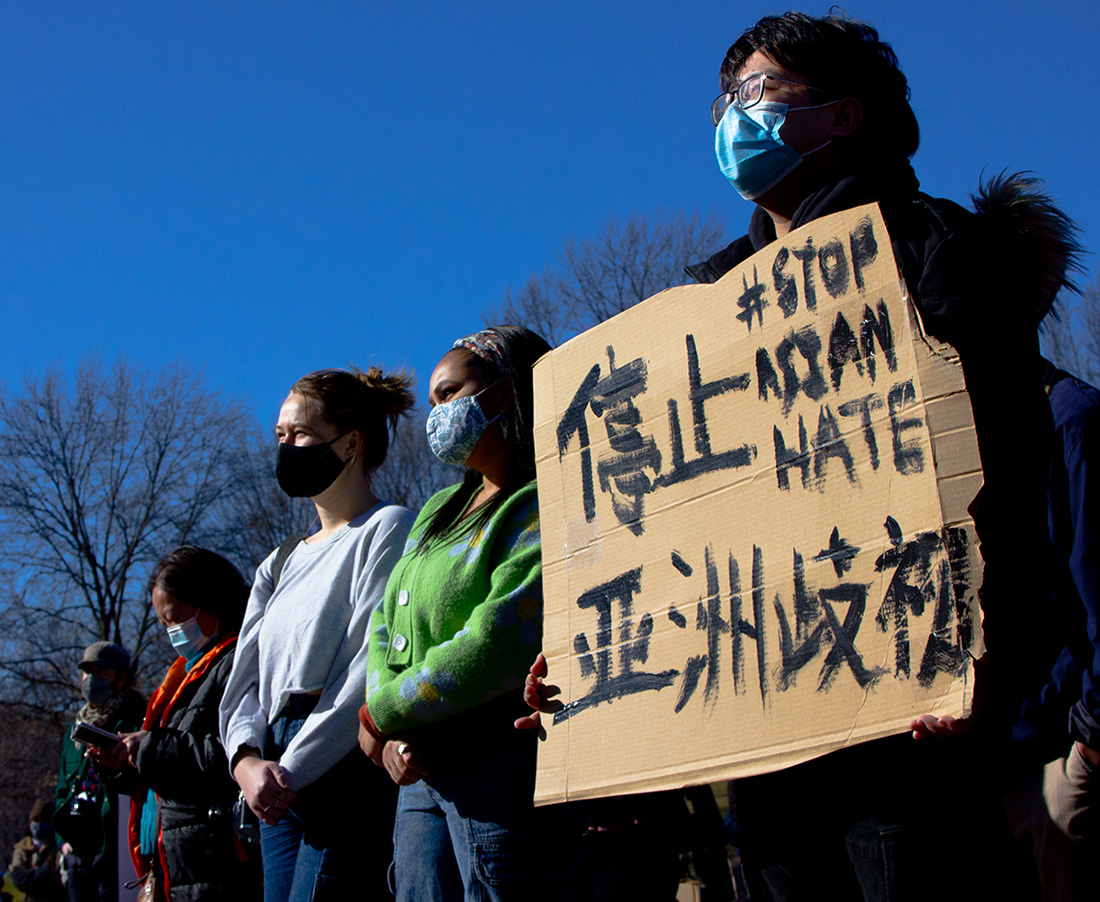 demonstrators hold signs at a stop asian hate protest