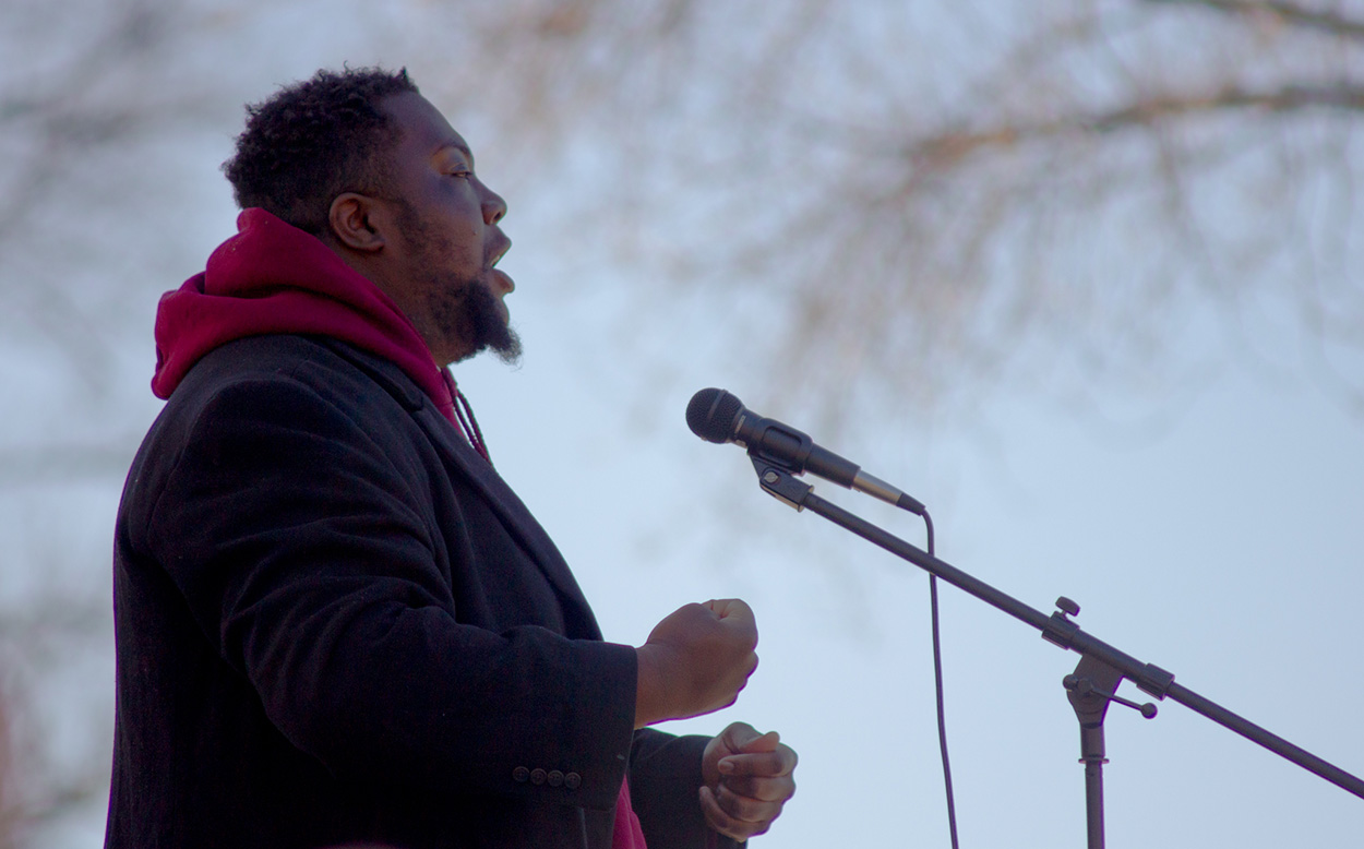justin singletary speaks at a stop asian hate protest in boston common