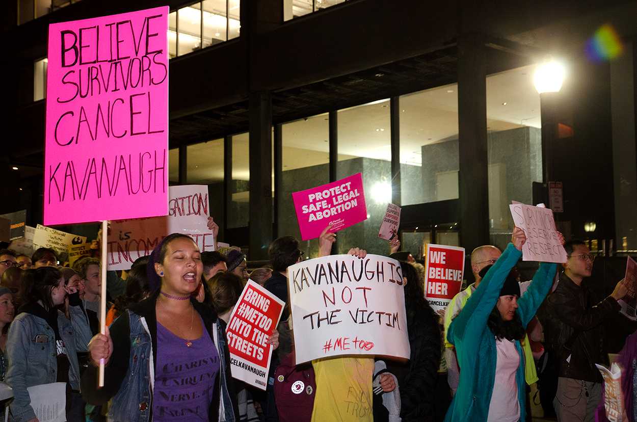 Protesters gathered by the Massachusetts State House Friday night, the eve of the vote to confirm U.S. Supreme Court Justice Brett Kavanaugh. GUTHRIE KUCKES/ DAILY FREE PRESS STAFF