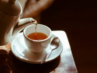 teapot pours tea into a teacup