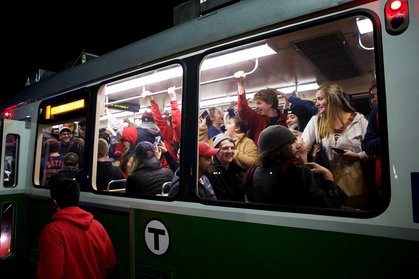 Several Boston University students join animated Red Sox fans onboard the Green Line en route to the Boston Common at Park Street, following the Sox’s 5-1 victory in Game 5 of the World Series Sunday night. OLIVIA FALCIGNO/ DAILY FREE PRESS STAFF