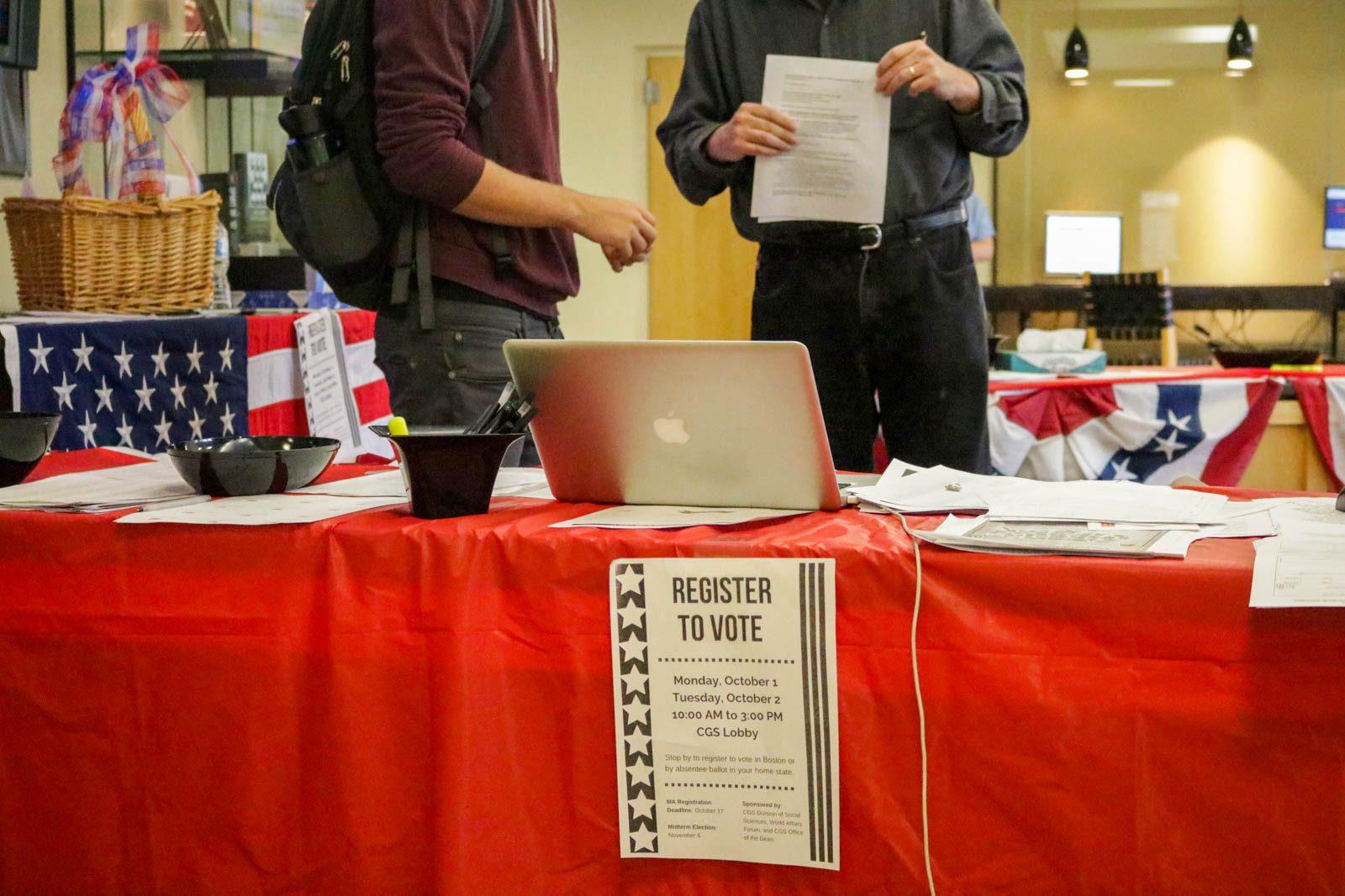 A student hands in his voter registration form to professor Chris Fahy at a voter registration drive hosted by the College of General Studies and the World Affairs Forum. SOFIA KOYAMA/ DAILY FREE PRESS STAFF