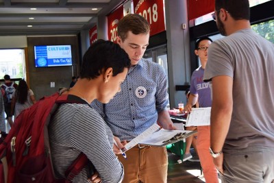 Jared Moffat, a field director for Regulate Mass, provides a student with information on voting at the voter registration drive hosted by the BU College Democrats Thursday in the George Sherman Union. PHOTO BY ELLEN CLOUSE/ DAILY FREE PRESS STAFF