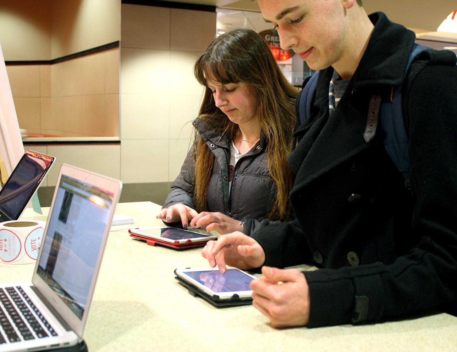 Brooke Washabaugh (CGS '18) and Aidan Donohue (CGS '18) vote for BU's next Student Government leaders Monday in the George Sherman Union. Students will vote for or against fossil fuel divestment on the student link ballot. PHOTO BY BETSEY GOLDWASSER/DAILY FREE PRESS STAFF
